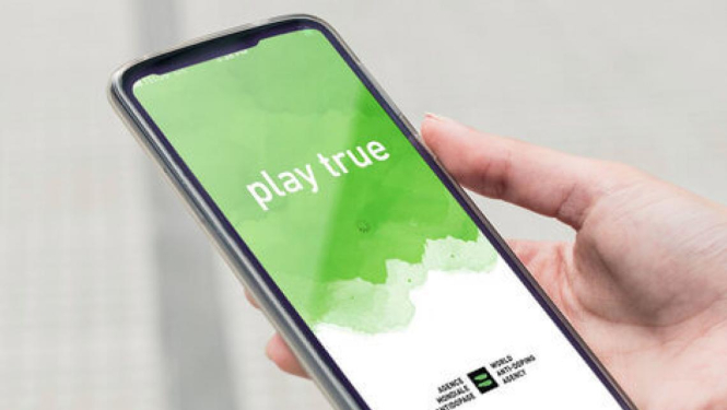 Cilvēka plauksta, kas rokās tur viedtālruni, kura ekrānā ir attēlots attēls ar tekstu "Play True"
